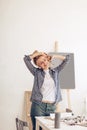 Young artist woman stretching her arms after working for a long time