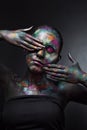 Young artistic woman in black paint and colourful powder. Glowing dark makeup. Creative body art on the theme of space Royalty Free Stock Photo