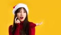 Young asain woman in red sweatshirt wearing santa hat posing surprised on yellow background. Merry Christmas Royalty Free Stock Photo