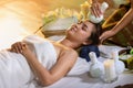 Young Asia beautiful woman during massage with spa herbal compress with oil and herbal set near site, relaxing and healthy Royalty Free Stock Photo