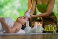 Young Asia beautiful woman during massage with spa herbal compress with oil and herbal set near site, relaxing and healthy concept Royalty Free Stock Photo