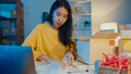 Young Asia businesswoman packing glass use bubble wrap for packing support damage fragile product in home office at night. Small Royalty Free Stock Photo