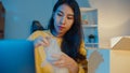 Young Asia businesswoman packing glass use bubble wrap for packing support damage fragile product in home office at night. Small Royalty Free Stock Photo