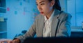 Young Asia cheerful professional woman sitting on desk focus concentrate working on laptop and digital tablet check detail final