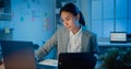 Young Asia cheerful professional woman sitting on desk focus concentrate working on laptop and digital tablet check detail final