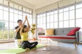 Young Asia couple practicing yoga lesson, breathing, meditating together and watching videos on laptop in living room at home. hea Royalty Free Stock Photo