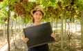 Young Asia farmer woman holding blackboard in grapes vineyard, healthy organic fruit concept Royalty Free Stock Photo