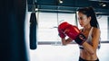 Young Asia lady kickboxing exercise workout punching bag tough female fighter practice boxing in gym fitness class. Sportswoman Royalty Free Stock Photo