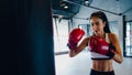 Young Asia lady kickboxing exercise workout punching bag tough female fighter practice boxing in gym fitness class. Sportswoman Royalty Free Stock Photo