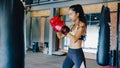 Young Asia lady kickboxing exercise workout punching bag tough female fighter practice boxing in gym fitness class. Sportswoman Royalty Free Stock Photo