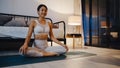 Young Asia lady in sportswear doing yoga exercise working out in living room at home at night. Sport and recreation activity, Royalty Free Stock Photo