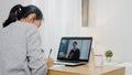 Young Asia teen girl university student using laptop computer distance learning lesson with male teacher remote teaching on Royalty Free Stock Photo