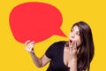 Young Asia woman holding red speech bubble on yellow background. Asian female show sign speech bubble banner, pretty girl look Royalty Free Stock Photo