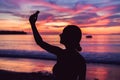 Young asia woman selfie with mobile phone on a beach at sunset in summer, Phuket, Thailand Royalty Free Stock Photo