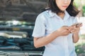 Young asia woman sitting in front of her car, try to calling for assistance with her car broken down Royalty Free Stock Photo