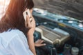 Young asia woman sitting in front of her car, try to calling for assistance with her car broken down Royalty Free Stock Photo