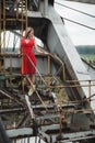 Young asial girl in red dress on iron excavator background