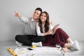 Young asian adult couple sitting on flor planning new home design. Royalty Free Stock Photo