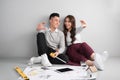 Young asian adult couple sitting on flor planning new home design. Royalty Free Stock Photo