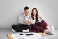 Young asian adult couple sitting on flor planning new home design. Royalty Free Stock Photo