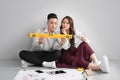 Young asian adult couple sitting on flor planning new home design. Royalty Free Stock Photo