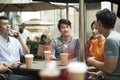 Young asian adults relaxing at outdoor coffee shop Royalty Free Stock Photo