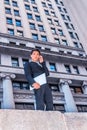 Young Asian American college student talking on cell phone outside office building in New York City Royalty Free Stock Photo