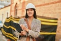 Young asian architect woman smiling happy writing on clipboard at the city