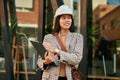 Young asian architect woman smiling happy writing on clipboard at the city