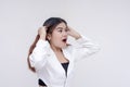 A young asian astonished by something, taken aback and pulls her hair. Isolated on a white background