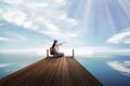 Young asian backpacker woman sitting and pointing blue sky