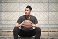 Young asian basketball player resting at courtside Royalty Free Stock Photo