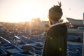 Young Asian Bearded Tourist man with Dreadlocks and scarf on head Looking at Blue Fishermans boats in Essaouira, Morocco