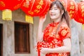 Young asian beautiful girl in chinese traditional red dress smile stand near china lamp, in the Chinese New Year. Festivities. Royalty Free Stock Photo