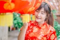 Young asian beautiful girl in chinese traditional red dress smile stand near china lamp, in the Chinese New Year. Festivities. Royalty Free Stock Photo