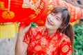 Young asian beautiful girl in chinese traditional red dress smile stand near china lamp, in the Chinese New Year. Festivities. Royalty Free Stock Photo