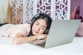 Young asian beautiful internet addict woman in pajamas on bed at home bedroom asleep while working with laptop computer, Resting Royalty Free Stock Photo