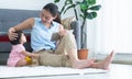 Young Asian beautiful mother sitting on floor, working with tablet while stroking her cute little Caucasian 7 months newborn baby Royalty Free Stock Photo