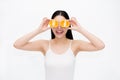 Young Asian beautiful smiling woman in black hair and white vest holding pieces of citrus oranges in fun and happiness emotion Royalty Free Stock Photo