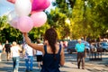 Young asian beautiful woman with flying multicolored balloons in the city. Royalty Free Stock Photo