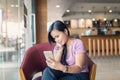 Young Asian beautiful woman using smart phone in coffee shop Royalty Free Stock Photo