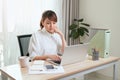 Young Asian beautiful woman works for a computer from a home with a laptop at desk as a freelancer Royalty Free Stock Photo