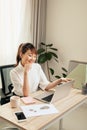 Young Asian beautiful woman works for a computer from a home with a laptop at desk as a freelancer Royalty Free Stock Photo