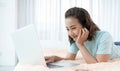 Young Asian beauty woman working on laptop in the bed at home. Royalty Free Stock Photo