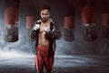 Young asian boxer man in a black robe with punching bag Royalty Free Stock Photo