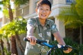 Young Asian boy on his bike in front of the house Royalty Free Stock Photo