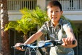 Young Asian boy on his bike in front of the house Royalty Free Stock Photo