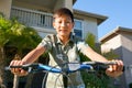 Young Asian boy on his bike in front of the house Royalty Free Stock Photo