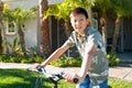 Young Asian boy on his bike in front of the house Royalty Free Stock Photo