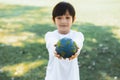 Young asian boy holding planet Earth globe at natural park background. Gyre Royalty Free Stock Photo